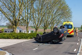 Auto botst op betonblok en vliegt over de kop